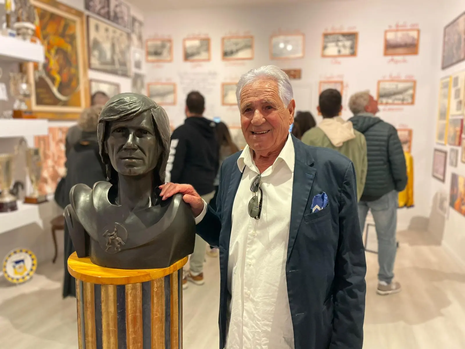 Andrea "Aceto" Degortes accanto al busto che lo raffigura, nel museo di Asciano