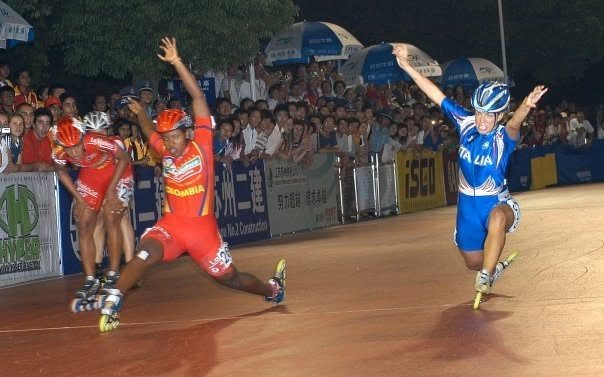 Arrivo in volata con le braccia alzate accanto alle atlete della Colombia