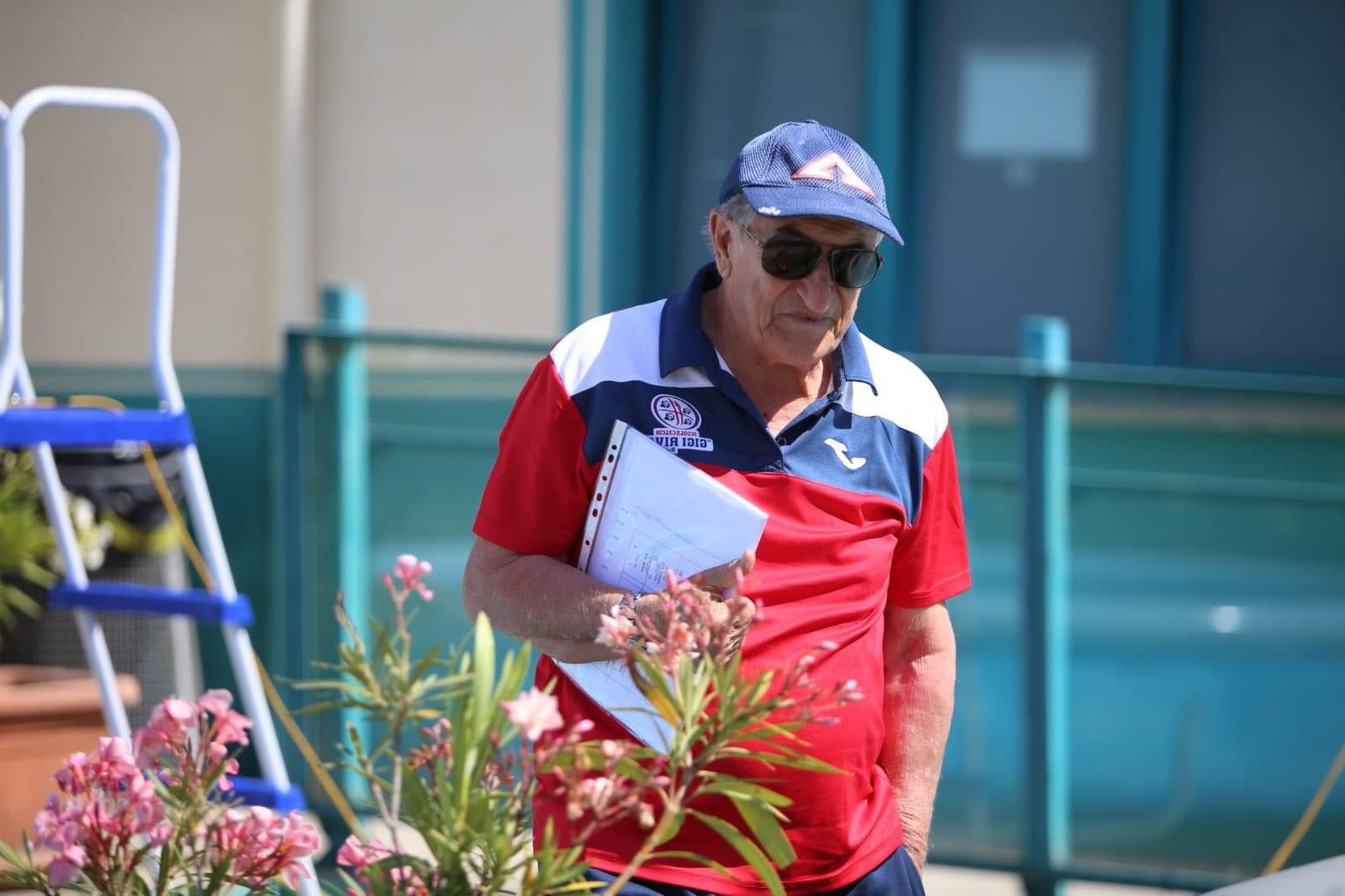 Ritratto di Enzo Molinas con la polo della Scuola calcio Gigi Riva