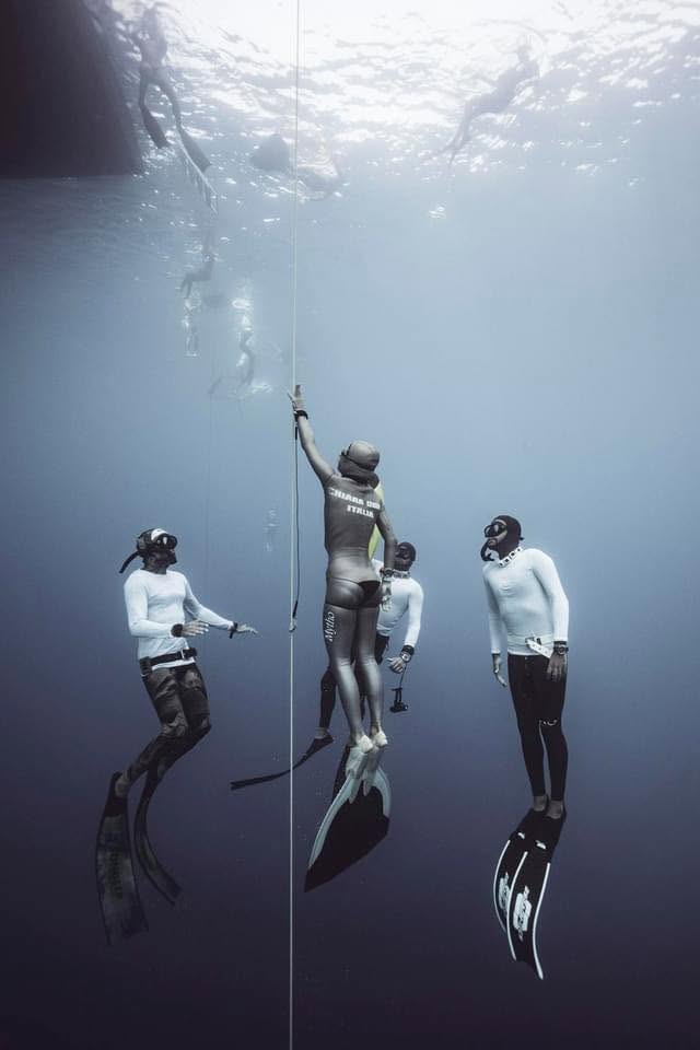 Chiara Obino con la muta Italia inizia la discesa lungo il cavo circondata dai safety diver